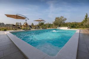 罗波里卡Ferienhaus mit Privatpool für 7 Personen ca 200 qm in Loborika, Istrien Südküste von Istrien的一个带蓝色水和遮阳伞的游泳池