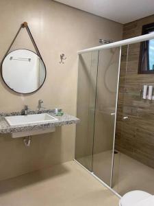 Represa CapivariApartamento completo em Resort的带淋浴、盥洗盆和镜子的浴室