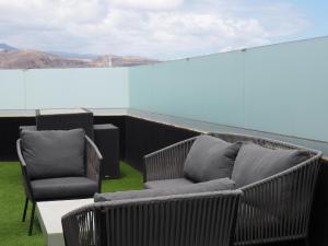 大加那利岛拉斯帕尔马斯Ferienwohnung für 2 Personen ca 28 qm in Las Palmas de Gran Canaria, Gran Canaria Nordküste Gran Canaria的屋顶上摆放着两把椅子和一张沙发