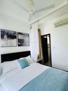 KikambalaChalbi residence-beach apartment at sultan palace的一间卧室配有一张白色的床和蓝色的毯子