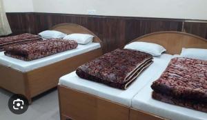 巴德里纳特OM Kutir Badrinath Dham的双床间位于带2张单人床的客房内。