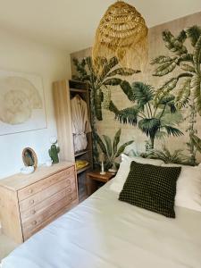 滨海卡瓦莱尔Appartement Sea Shell的一间卧室设有床铺和植物墙