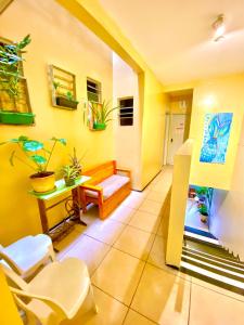 蒂安瓜Pousada Tianguá - Top Demais的客厅设有黄色的墙壁和桌椅