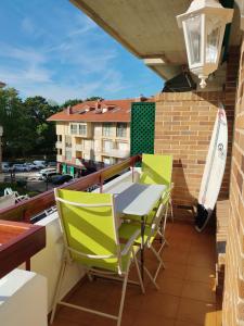 圣维森特-德拉巴尔克拉Apartamento a 30 metros de la playa的阳台配有桌椅和冲浪板