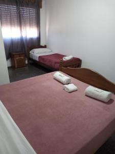 圣罗莎La Nueva Estancia的一间卧室配有两张床,床上配有毛巾