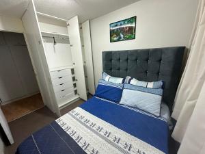 利马595 Departamento en Chorrillos的一间卧室配有一张蓝色的床和一个衣柜