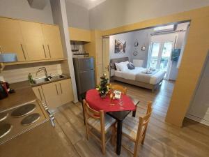 约阿尼纳Φιλοξενία的厨房以及带红色桌椅的起居室。