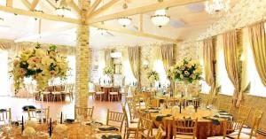 ToliejaiVila "Santa Barbara"的宴会厅配有桌椅和鲜花