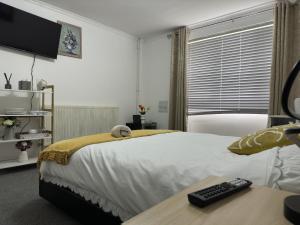 诺丁汉Comfy Room in Nottingham的一间卧室配有一张带电视和书桌的床。