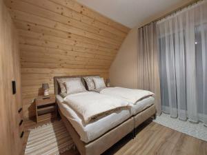 赖曼瑙-兹德鲁伊Agroturystyka Bliżej Natury的一间卧室设有一张床和木墙