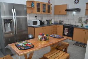 温特和克Wanjara's Nest的厨房配有木桌和冰箱。