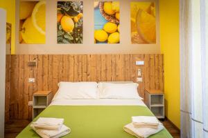 斯培西亚i sapori del levante的卧室配有一张绿色床,墙上挂有图片