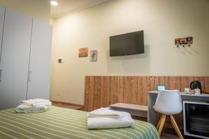 斯培西亚i sapori del levante的酒店客房设有一张床和墙上的电视