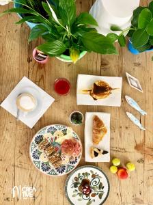 里米尼Hotel Nizza Creative Hotel的餐桌,餐桌上放有食物和植物的盘子