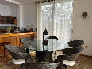 Puerto Velasco IbarraVILLA FLOREANA的一间设有玻璃桌和椅子的用餐室