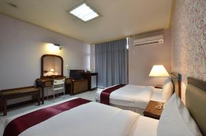 台南均英商务饭店的酒店客房,设有两张床和镜子
