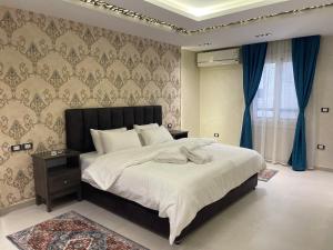 开罗ArabElite的一间卧室配有大床和蓝色窗帘