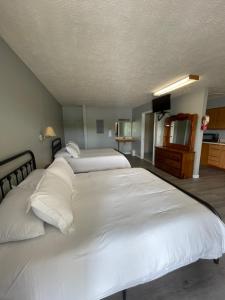 CadizMoon River Marina & Resort的一间卧室配有两张白色的床和电视