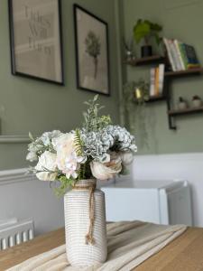 ThamesmeadGrace House - 15 Minutes To Central London的花瓶,花朵放在桌子上
