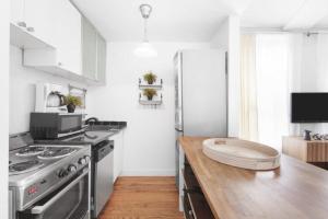 纽约139-2E west village 1BR best value的厨房配有不锈钢冰箱和木制柜台。