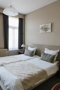 卡斯特尔莱Hotel Kempenrust的配有白色床单的酒店客房内的两张床