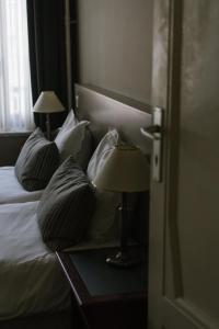 卡斯特尔莱Hotel Kempenrust的一间卧室配有一张带枕头的床和一张带台灯的桌子