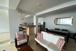 塞鲁阿苏尔Departamento de playa frente al mar的带沙发和椅子的客厅以及厨房。