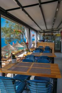 萨兰达Fabeno Villa的一间设有木桌和椅子的餐厅以及海滩