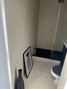乐巴凯尔斯Appartement vue mer的一间浴室,配有卫生间,地板上还挂着一幅画