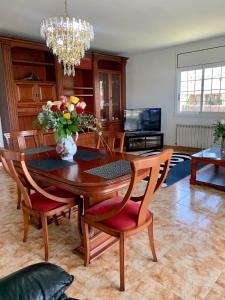 比利亚努埃瓦-赫尔特鲁Villa Felicidad的餐桌和椅子,花瓶