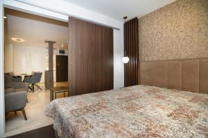 Novi BeogradPiano Luxe Apartment with Sauna的酒店客房设有一张大床和一张桌子。
