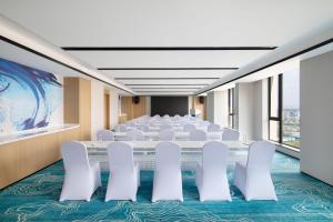 成都成都高新万枫酒店的一间会议室,配有白色的椅子和桌子