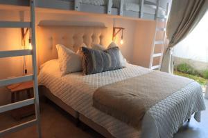 帕拉卡斯Acogedora Casa en Condominio Oasis的卧室配有白色的床和梯子