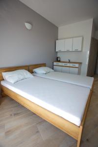 尤斯托尼莫斯基Planeta的一间卧室配有一张带白色床单的大床