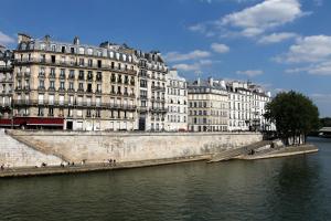 巴黎Hôtel L de Lutèce的一座大建筑,毗邻一条河,有建筑物
