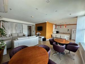 巴西利亚Flat Saint Moritz Brasília Hotel的一间带桌椅的客厅和一间厨房