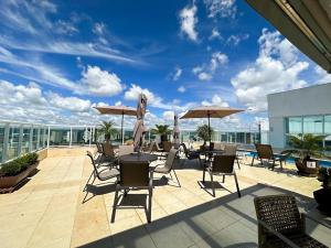 巴西利亚Flat Saint Moritz Brasília Hotel的大楼内带桌椅和遮阳伞的天井。