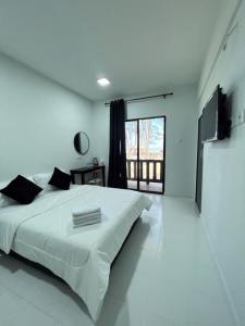 巴佐Chalet Barokah Resort, Bachok的白色的卧室设有一张大床和一个大窗户
