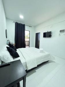 巴佐Chalet Barokah Resort, Bachok的卧室配有一张白色大床和电视。
