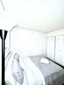 迈阿密Private bedroom 1 block from Downtown Miami的白色卧室配有床和灯
