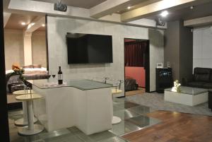 蟹江HOTELウォーターゲート蟹江（カップル専用）的客厅设有酒吧和平面电视。