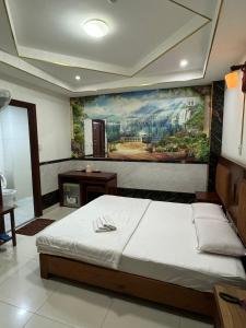 胡志明市Hoàng Thiên Lộc Hotel -199 Hoàng Hoa Thám, Q. Tân Bình - by Bay Luxury的卧室配有一张大床,墙上挂有绘画作品