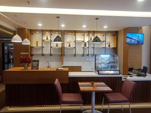 安汶马尼斯酒店的一间带柜台、椅子和桌子的餐厅