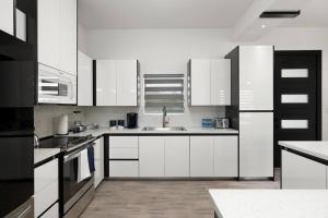 麦卡伦Quinta Real 5121 QR4的厨房配有白色橱柜和水槽