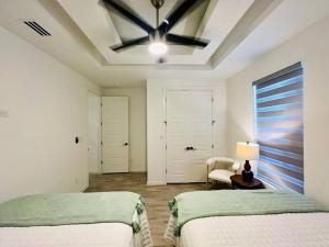 麦卡伦Quinta Real 5121 QR4的一间卧室配有两张床和吊扇