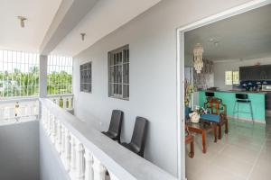 圣多明各Casa cerca SDQ & Bus Caribe tours的一个带椅子的阳台和一个厨房。