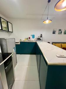 胡志明市Maison Bùi Viện的厨房配有绿色橱柜和白色台面