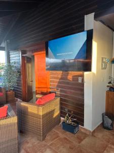 圣弗朗西斯科德马科里斯Rooftop Paradise的客厅配有2把藤椅和大屏幕电视