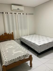 博尼图Casa com piscina e churrasqueira的两张床位于带窗户的房间内