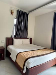 波来古市Hoàng Khiêm Hotel的一间卧室配有一张带蓝色窗帘的大床